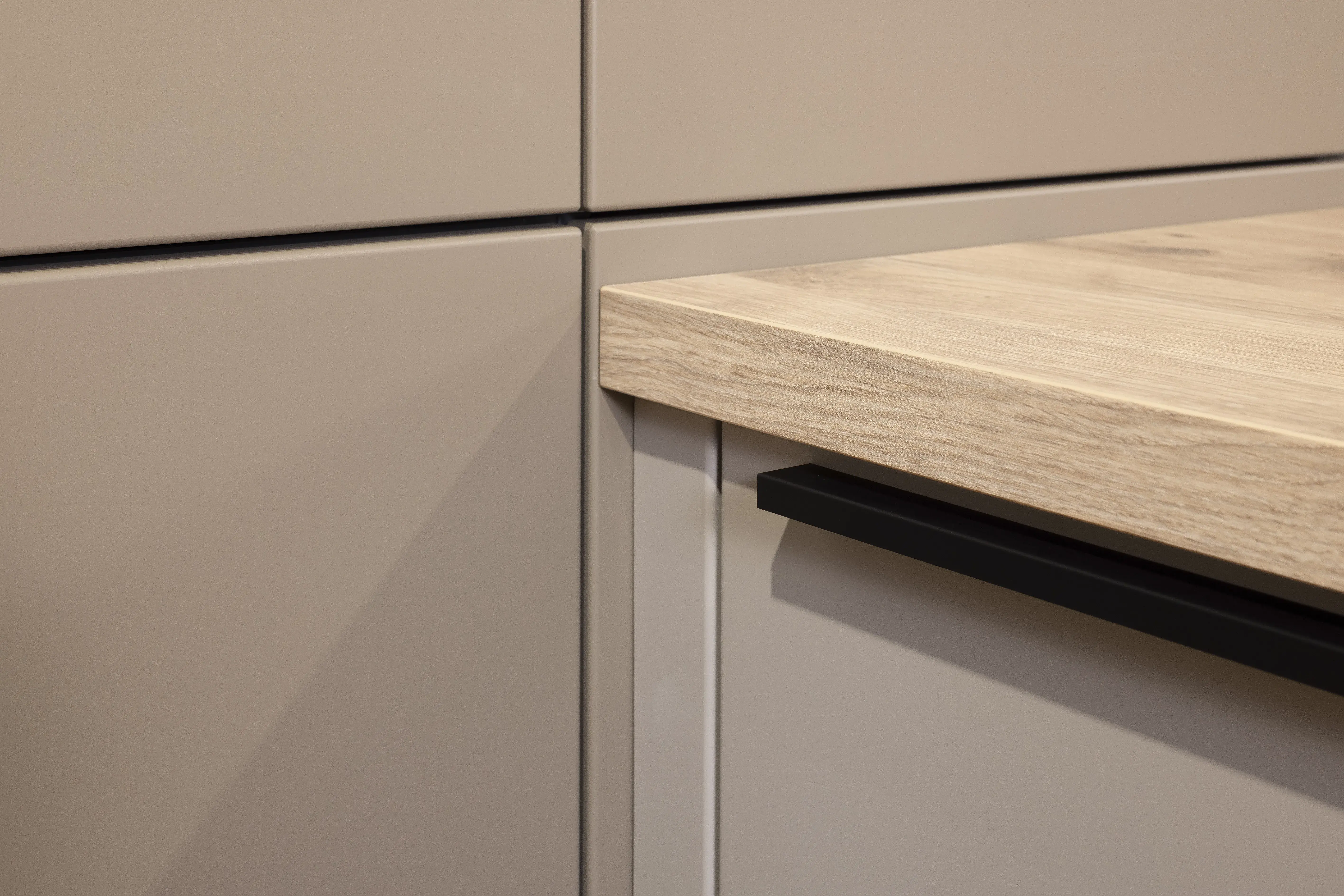 APL: Patagonia Eiche NB Front: Kaschmirbraun satin Front: Sepiabraun satin Korpus: Lavaschwarz Griff: Metall Schwarz Geräte: Bosch Armatur: Blanco Spüle: Blanco   Features: Farbkombination mit zwei Brauntönen kombiniert mit Eiche APL und Nischenrückwand (NB), Oberschrankplanung, Ablageraum auf Augenhöhe, Thekenlösung mit Tisch, Dunstabzugshaube (Airforce), Edelstahl Aufsatzspüle, Schiebeelemente.