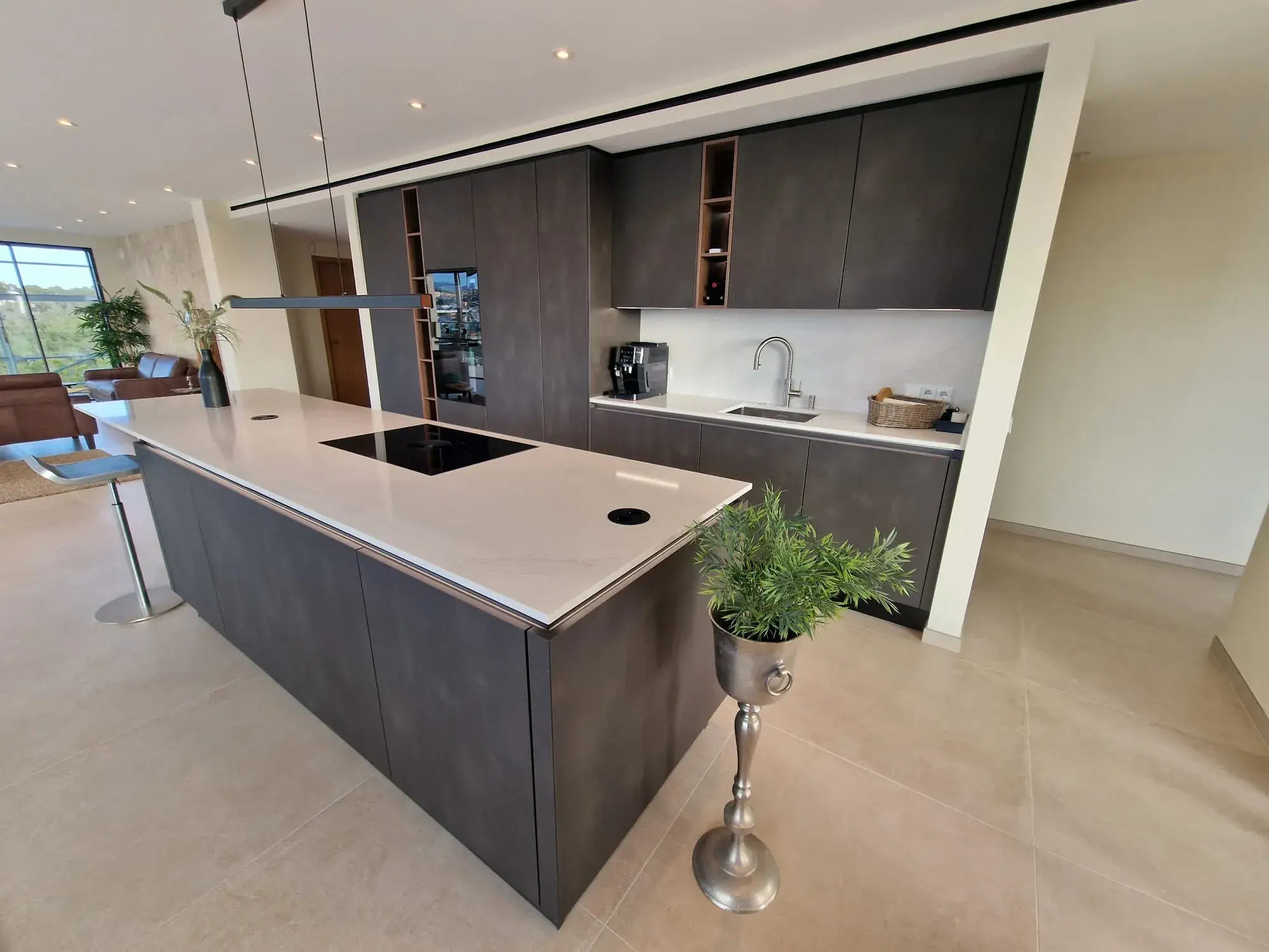 Moderne Designküche mit Kochinsel, grifflosen Fronten und integriertem Sitzbereich - Teilansicht