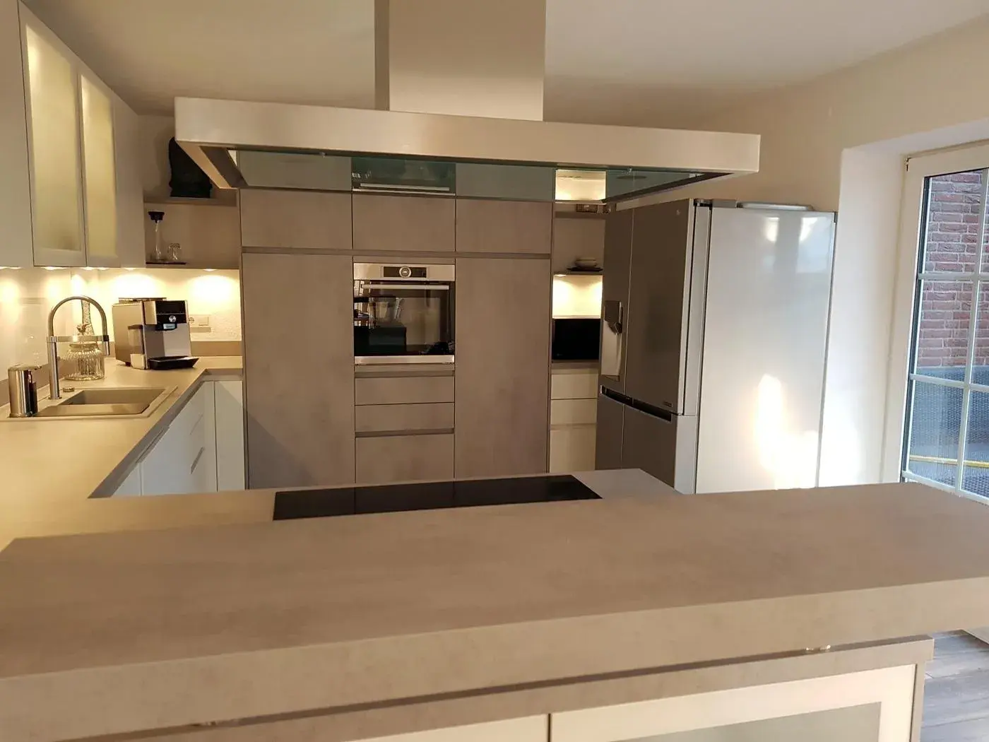 Küche mit theke und Hochschrank und Betonfronten 